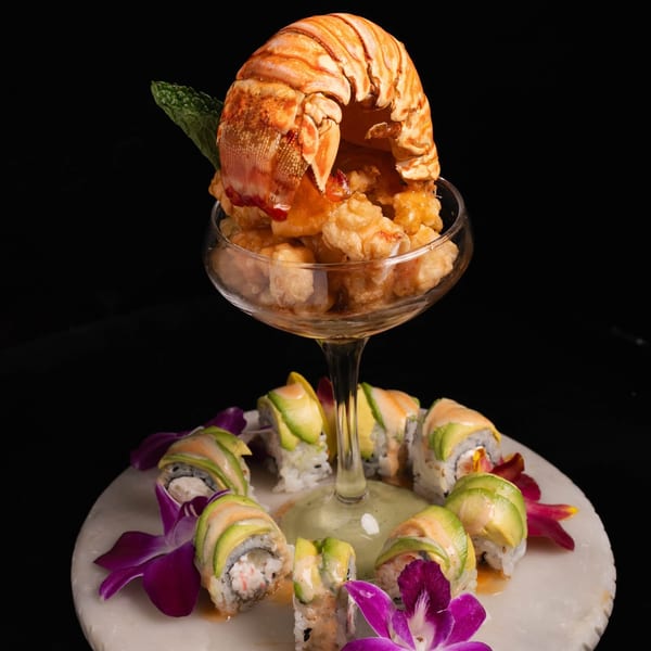 Neveyah Sushi and Thai's lobster tail and fried shrimp cocktail with avocado sushi rolls on a marble plate.