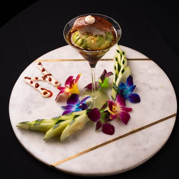 Neveyah Sushi and Thai's sushi martini with avocado, tuna, and rice, garnished with orchids and cucumber.