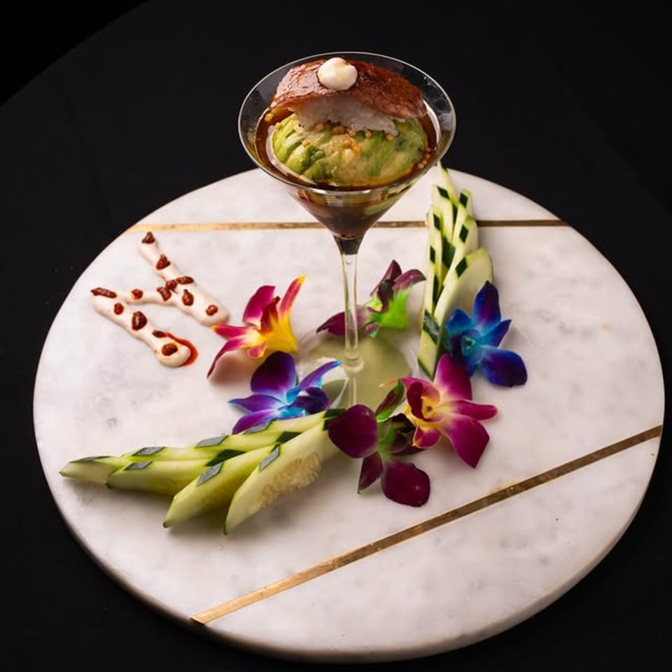 Neveyah Sushi and Thai's sushi martini with avocado, tuna, and rice, garnished with orchids and cucumber.